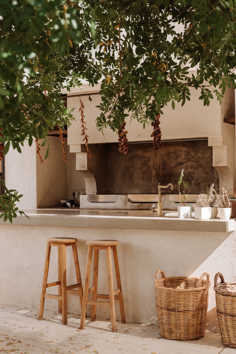 A kitchen with two stools under a tree